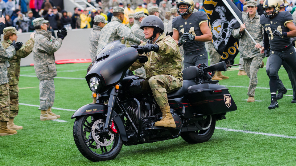Lt. Gen. Robert L. Caslen, Jr., Superintendent of the U.S. Military Academy, leads the Army West Point Football team into Michie Stadium on a motorcycle especially designed for the family of fallen Cadet Thomas Surdyke, Oct. 22 at West Point. The custom bike commemorates five cadets and recent graduates who have passed away this year. (U.S. Army photo by: Maj. Scot Keith)

